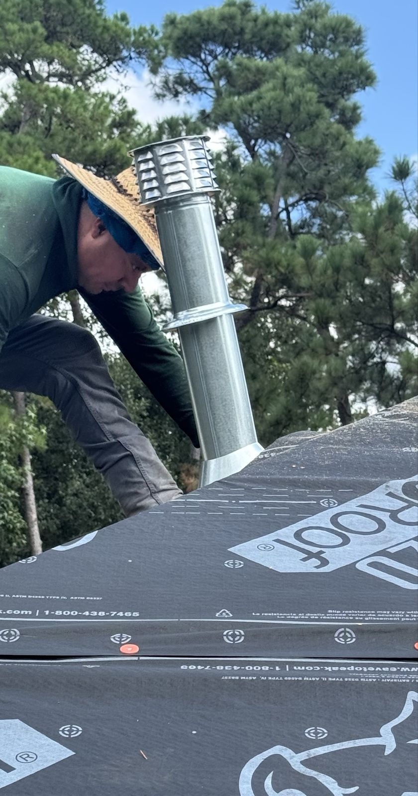 Crew installing a roof vent during a shingle installation